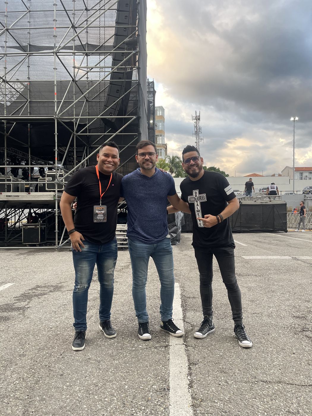 Juan Balza con dos colegas frente a la estructura de una tarima en pleno montaje